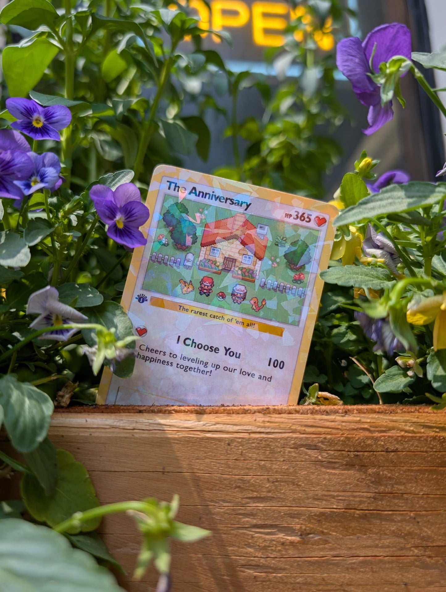 Anniversary collectible card with a garden scene among flowers and plants